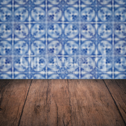 Wood table top and blur vintage ceramic tile pattern wall