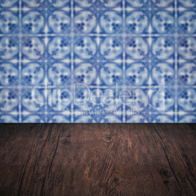 Wood table top and blur vintage ceramic tile pattern wall