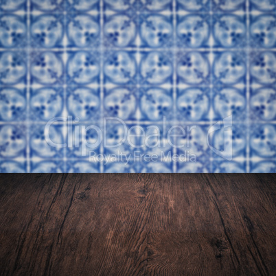 Wood table top and blur vintage ceramic tile pattern wall