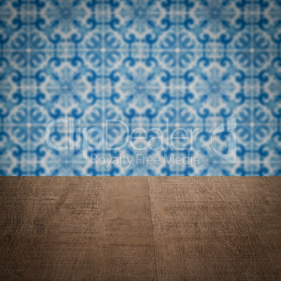 Wood table top and blur vintage ceramic tile pattern wall