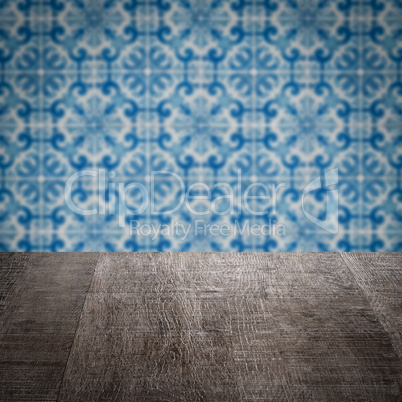 Wood table top and blur vintage ceramic tile pattern wall