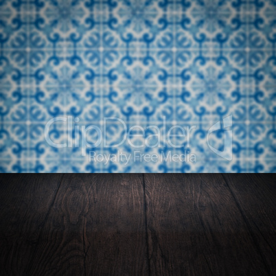 Wood table top and blur vintage ceramic tile pattern wall