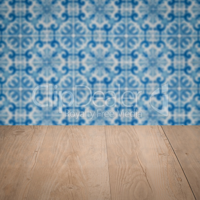Wood table top and blur vintage ceramic tile pattern wall Wood table top and blur vintage ceramic tile pattern wall