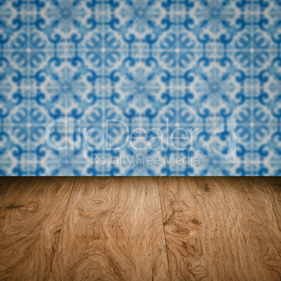 Wood table top and blur vintage ceramic tile pattern wall