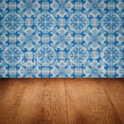 Wood table top and blur vintage ceramic tile pattern wall