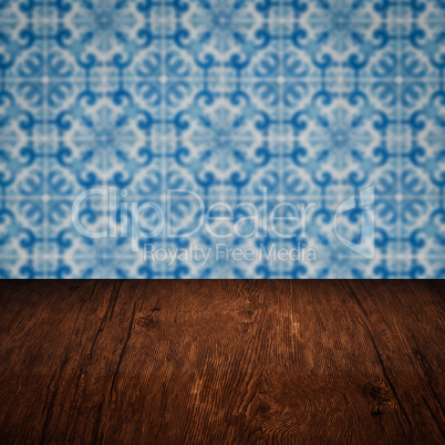 Wood table top and blur vintage ceramic tile pattern wall