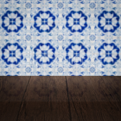 Wood table top and blur vintage ceramic tile pattern wall