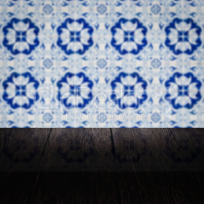 Wood table top and blur vintage ceramic tile pattern wall