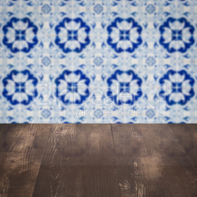 Wood table top and blur vintage ceramic tile pattern wall Wood table top and blur vintage ceramic tile pattern wall