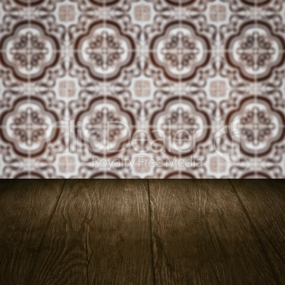 Wood table top and blur vintage ceramic tile pattern wall Wood table top and blur vintage ceramic tile pattern wall