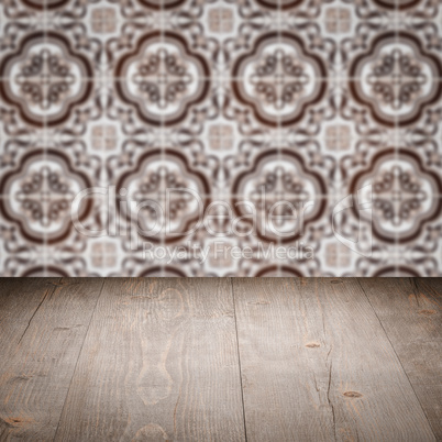 Wood table top and blur vintage ceramic tile pattern wall