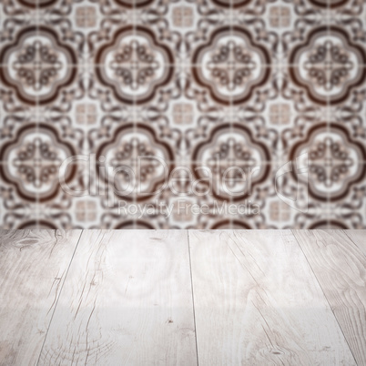 Wood table top and blur vintage ceramic tile pattern wall