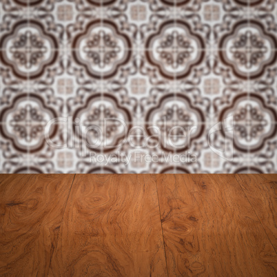 Wood table top and blur vintage ceramic tile pattern wall