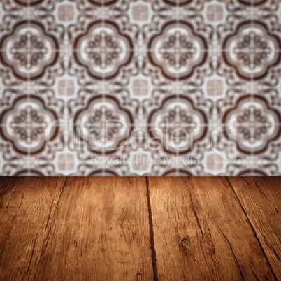 Wood table top and blur vintage ceramic tile pattern wall