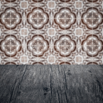 Wood table top and blur vintage ceramic tile pattern wall Wood table top and blur vintage ceramic tile pattern wall