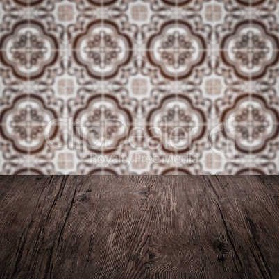 Wood table top and blur vintage ceramic tile pattern wall