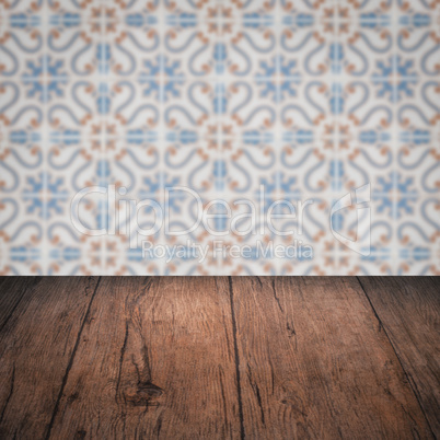 Wood table top and blur vintage ceramic tile pattern wall