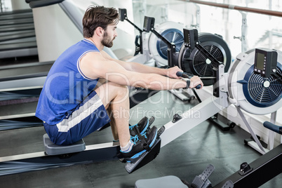 Handsome man doing exercise on drawing machine