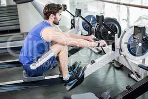 Handsome man doing exercise on drawing machine