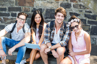 Hip friends holding tablet and smiling at the camera