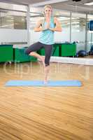 Fit woman doing yoga on mat