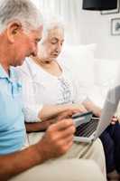 Smiling senior couple using laptop