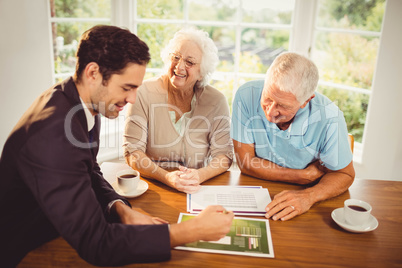 Businessman showing sheets to senior couple