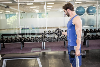 Muscular man lifting dumbbell