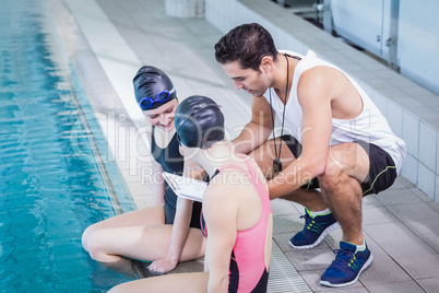 Smiling swimmers looking at clipboard