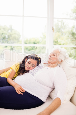 Relaxed granddaughter and grandmother napping