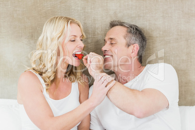 Husband giving a strawberry to wife
