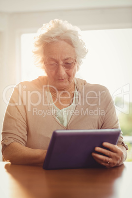 Focused senior woman using tablet