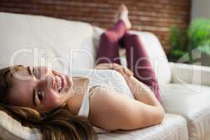 Smiling pretty woman lying on the couch