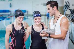 Trainer talking with smiling swimmers