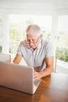 Focused senior man using laptop