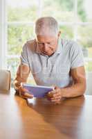 Focused senior man using tablet