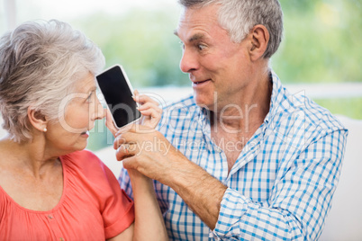 Happy senior couple listening to smartphone Happy senior couple listening to smartphone