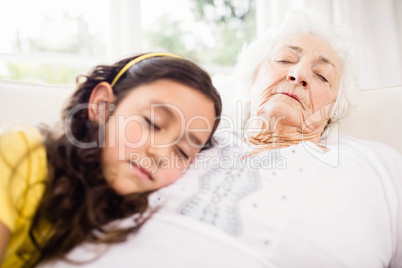 Relaxed granddaughter and grandmother napping