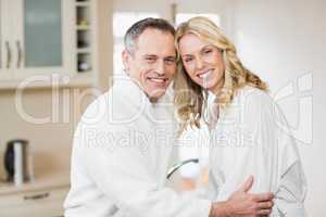 Cute couple cuddling in bathrobes