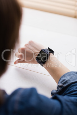 Casual businesswoman watching her smart watch