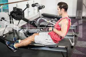 Muscular man on rowing machine