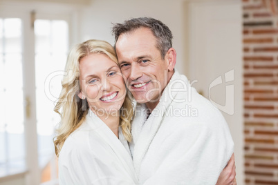 Cute couple cuddling in bathrobes