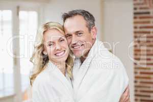 Cute couple cuddling in bathrobes