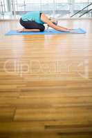 Fit blonde doing yoga on mat