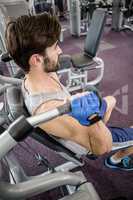 Focused man using weights machine for arms