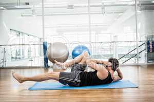 Muscular man doing abdominal on mat