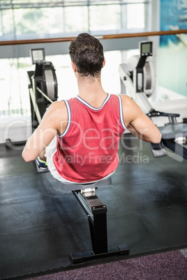 Muscular man on rowing machine