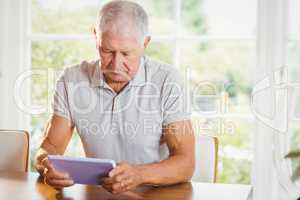 Focused senior man using tablet
