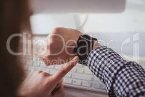 Over the shoulder view of businesswoman using her smart watch