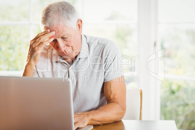 Worried senior man using laptop